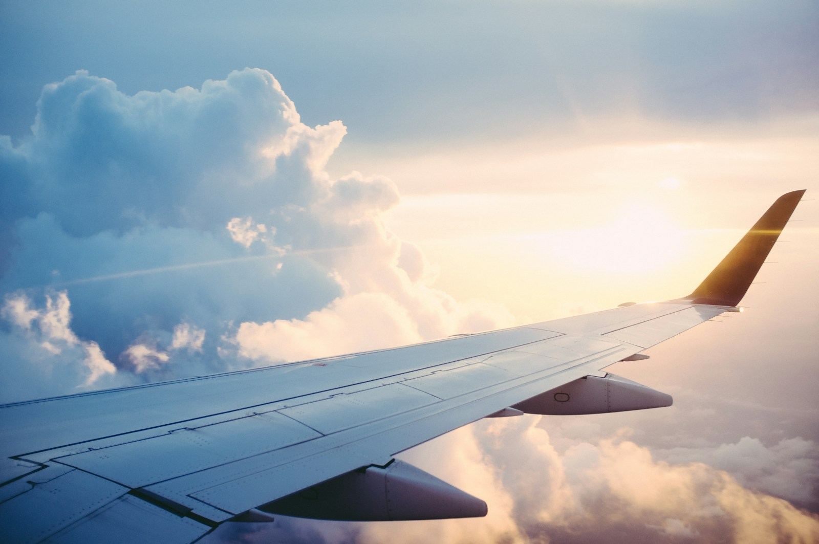 Aircraft wing above the clouds symbolising the global mobility delivered by citizenship by investment and golden visa programmes in 2026